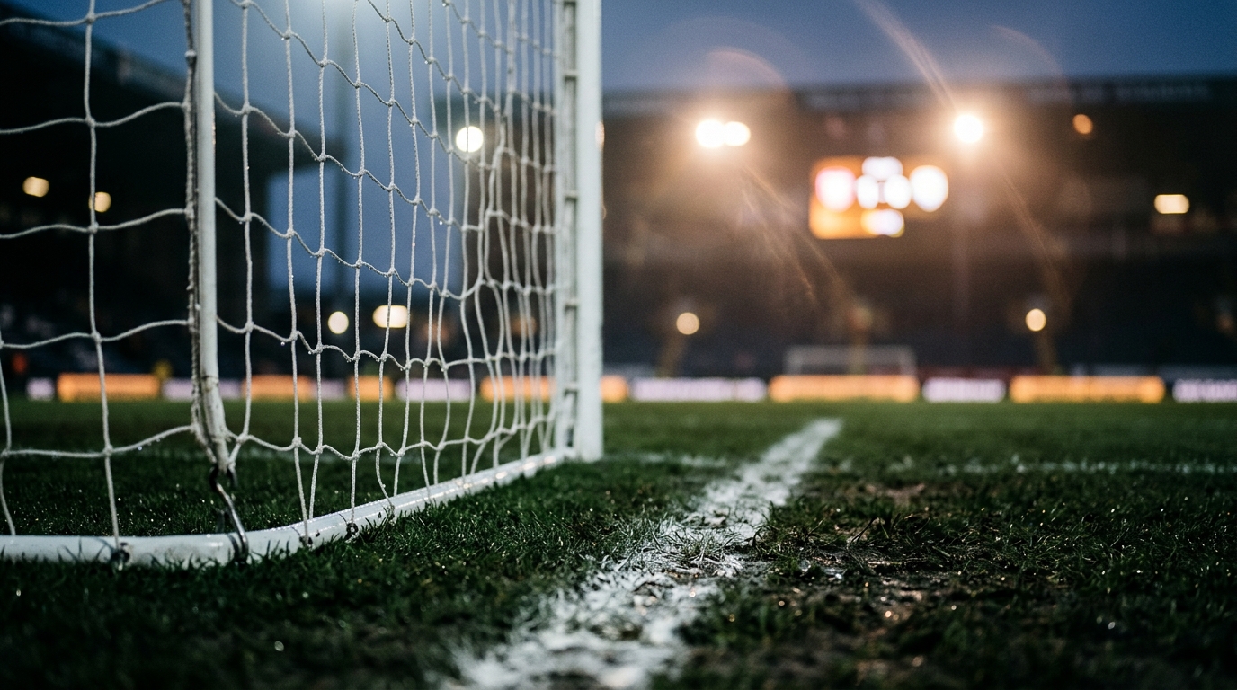 Goal net and touchline grass at full time under floodlights after a goalless draw